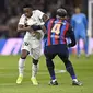 Bek Barcelona, Ronald Araujo mencoba menghadang winger Real Madrid, Vinicius Junior pada leg pertama semifinal Copa Del Rey, 2 Maret 2023. (AFP/Oscar Del Pozo)