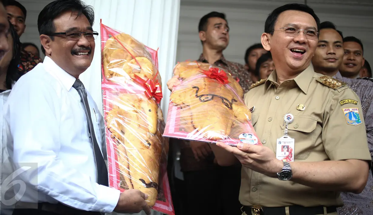 Gubernur DKI, Ahok dan Wagub DKI, Djarot Saiful Hidayat berpose dengan roti buaya di Balai Kota Jakarta, Senin (29/8). Roti buaya dari relawan Ahok-Djarot itu simbol warga meminang Ahok-Djarot pada Pilkada DKI Jakarta 2017. (Liputan6.com/Faizal Fanani)