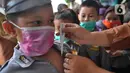 Guru memeriksa suhu tubuh seorang murid di  Taman Kanak-kanak (TK) RA Hidayatusshibyan Cinere, Depok, Kamis (5/3/2020). Mengantisipasi virus corona COVID-19, murid-murid diukur suhu tubuhnya  dan diwajibkan mencuci tangan mereka sebelum masuk kelas.  (merdeka.com/Arie Basuki)