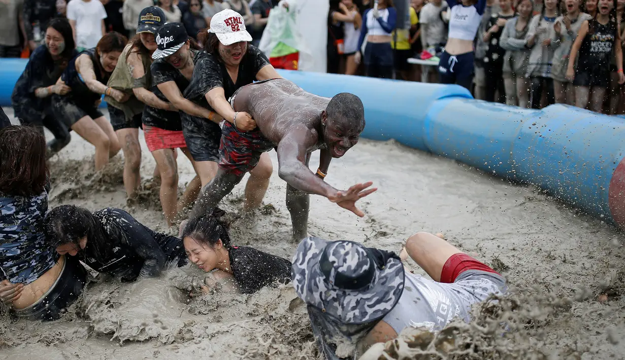 Sejumlah turis mengikuti sebuah permainan dalam Festival lumpur Boryeong di pantai Daecheon, Boryeong, Korea Selatan, (15/7). Festival lumpur Boryeong selalu mengadakan berbagai perlombaan yang menggunakan arena berlumpur. ( REUTERS/Kim Hong-Ji)