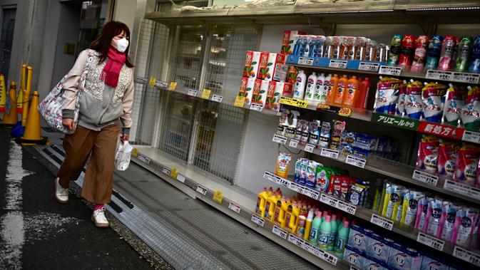 Seorang perempuan melewati stok tisu toilet yang habis di sebuah toko di Tokyo, Minggu (1/3/2020). Warga Jepang yang sedang waspada wabah virus corona tipe baru, Covid-19 dilanda kepanikan setelah muncul gosip bahwa China tidak akan lagi mengekspor kertas toilet. (CHARLY TRIBALLEAU/AFP)
