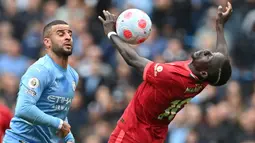 Striker Liverpool, Sadio Mane (kanan) mengontrol bola di depan bek Manchester City, Kyle Walker pada laga Liga Inggris 2021/2022 di Etihad Stadium, Manchester (10/4/2022). Sadio Mane menjuarai Liga Inggris bersama Liverpool pada musim 2019/2020. Sebelum diboyong The Reds pada awal musim 2016/2017 dari Southampton yang dibelanya pada 2014/2015 dan 2015/2016, Sadio Mane pernah membela RB Salzburg pada musim 2012/2013 dan 2013/2014. (AFP/Paul Ellis)