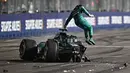 Pembalap Aston Martin, Lance Stroll, melompat keluar dari mobilnya setelah mengalami kecelakaan dalam sesi kualifikasi Formula One Grand Prix Singapore 2023 yang berlangsung di Marina Bay Street Circuit, Singapura, Sabtu (16/9/2023). (AFP/Lillian Suwanrumpha)