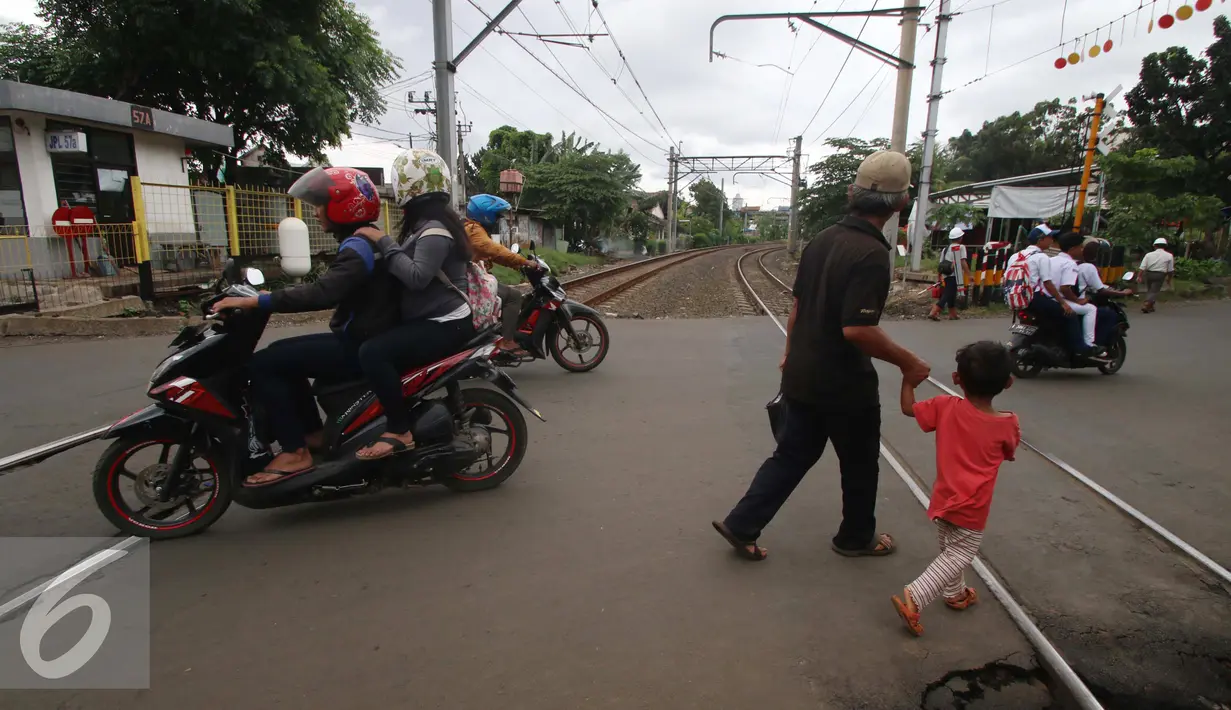 Warga melewati perlintasan kereta api Bintaro, Jakarta, Senin (16/1). Pada tahun 2017 Dinas Bina Marga DKI Jakarta akan membangun jembatan layang sepanjang 430 meter untuk menekan angka kecelakaan di kawasan tersebut. (Liputan6.com/Gempur M. Surya)