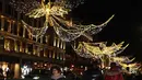 Orang-orang berjalan di sepanjang Regent Street yang dihiasi berbagai dekorasi lampu Natal di pusat kota London, Inggris (30/11/2020). (Xinhua/Han Yan)