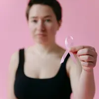 Wanita yang memegang pita pink di depan dada (Foto dok : Pexels/Thirdman).
