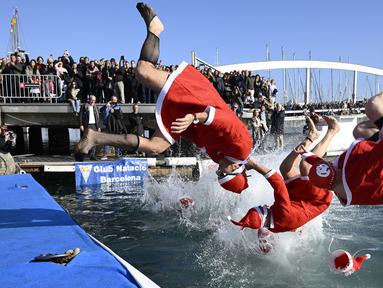 Sejumlah peserta mengenakan kostum Sinterklas dalam perlombaan renang bertajuk Copa Nadal (Piala Natal) edisi ke-115 yang berlangsung di Port Vell, Barcelona, Spanyol, Rabu (25/12/2024). Ajang tersebut diikuti oleh 450 peserta dengan jarak renang sejauh 200 meter. (AFP/Josep Lago)