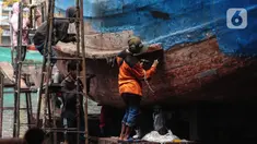 Buruh melakukan perbaikan kapal nelayan di Galangan kapal, Muara Angke, Jakarta, Minggu (23/12/2020). Dimasa pandemi Covid 19 aktivitas di galangan kapal tetap berjalan normal seperti biasa. (Liputan6.com/Angga Yuniar)