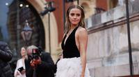 Aktris Inggris Emma Watson berpose di karpet merah saat tiba di BAFTA British Academy Film Awards di Royal Albert Hall, di London (13/3/2022). Emma Watson melengkapi ansambel sensasionalnya dengan sepasang anting rumbai perak mewah dan serangkaian cincin perak. (AFP/Tolga Akmen)