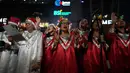 Bertempat di jalur pedestrian di depan FX Sudirman, Jakarta, acara ini melibatkan sekitar 1.200 hingga 1.400 penyanyi dari berbagai gereja dan komunitas. Tampak dalam foto, Umat Kristiani menyanyikan lagu-lagu Natal di Jakarta, Selasa 23 Desember 2025. (AP Photo/Dita Alangkara)