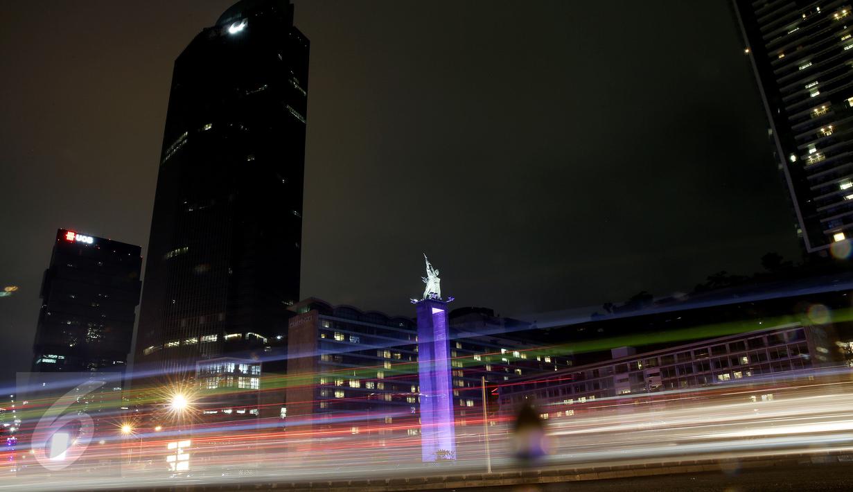 Monumen Selamat Datang dan gedung serta pusat perbelanjaan saat peringatan Earth Hour, Jakarta, Sabtu (19/3). Pemadaman serentak selama 60 menit pada pukul 20.30 hingga 21.30 WIB itu sebagai peringatan Hari Bumi (Earth Hour). (Liputan6.com/Faizal Fanani)