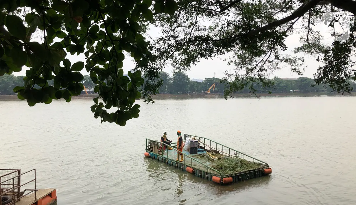 Petugas kebersihan mengumpulkan sampah di Perkampungan Budaya Betawi Setu Babakan, Jakarta, Senin (22/6/2020). Danau buatan seluas 30 hektare tersebut kembali dibuka untuk umum setelah sebelumnya ditutup untuk mencegah penyebaran virus corona COVID-19. (Liputan6.com/Immanuel Antonius)