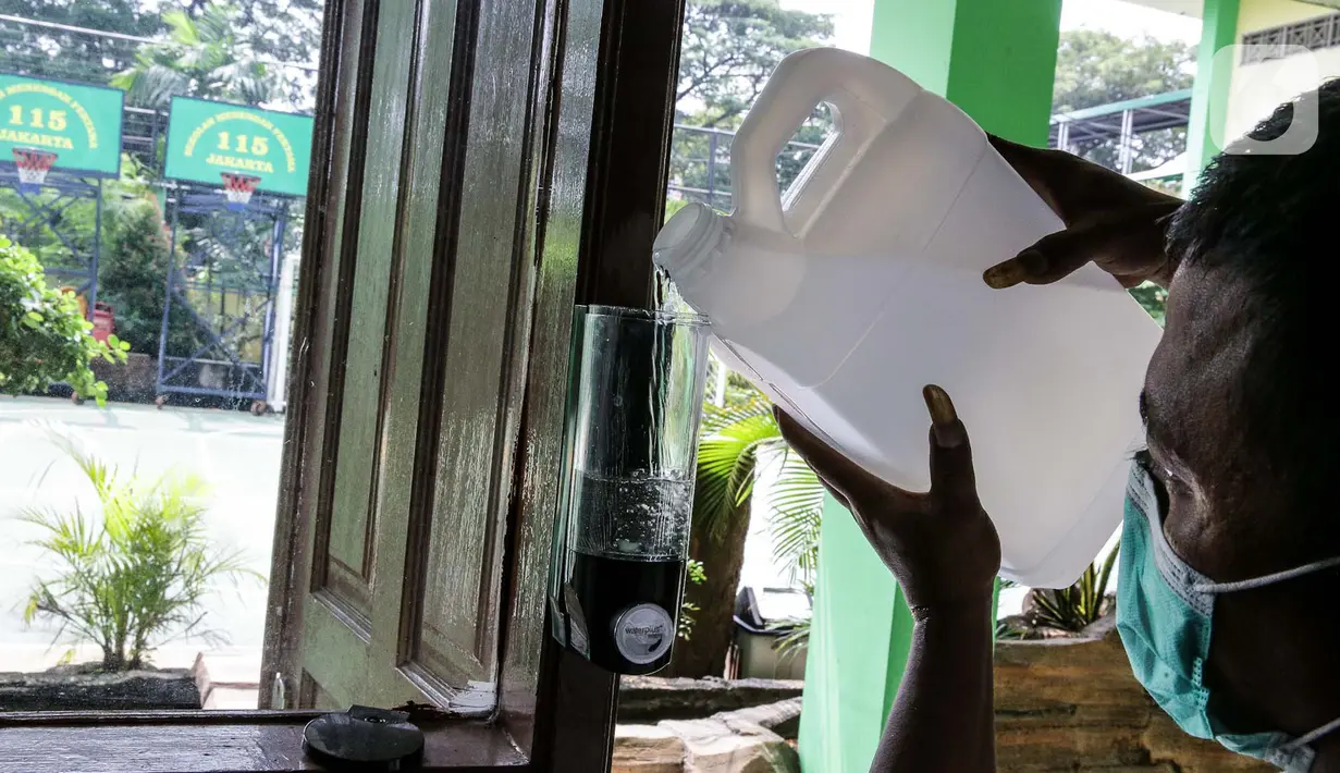 Petugas menyiapkan hand sanitizer di SMP N 115 Jakarta, Jumat (21/5/2021). Seleksi PPDB DKI Jakarta tahun ini akan dibagi menjadi empat bagian yakni jalur prestasi, jalur afirmasi, jalur zonasi, dan jalur pindah tugas orangtua dan anak guru. (Liputan6.com/Faizal Fanani)