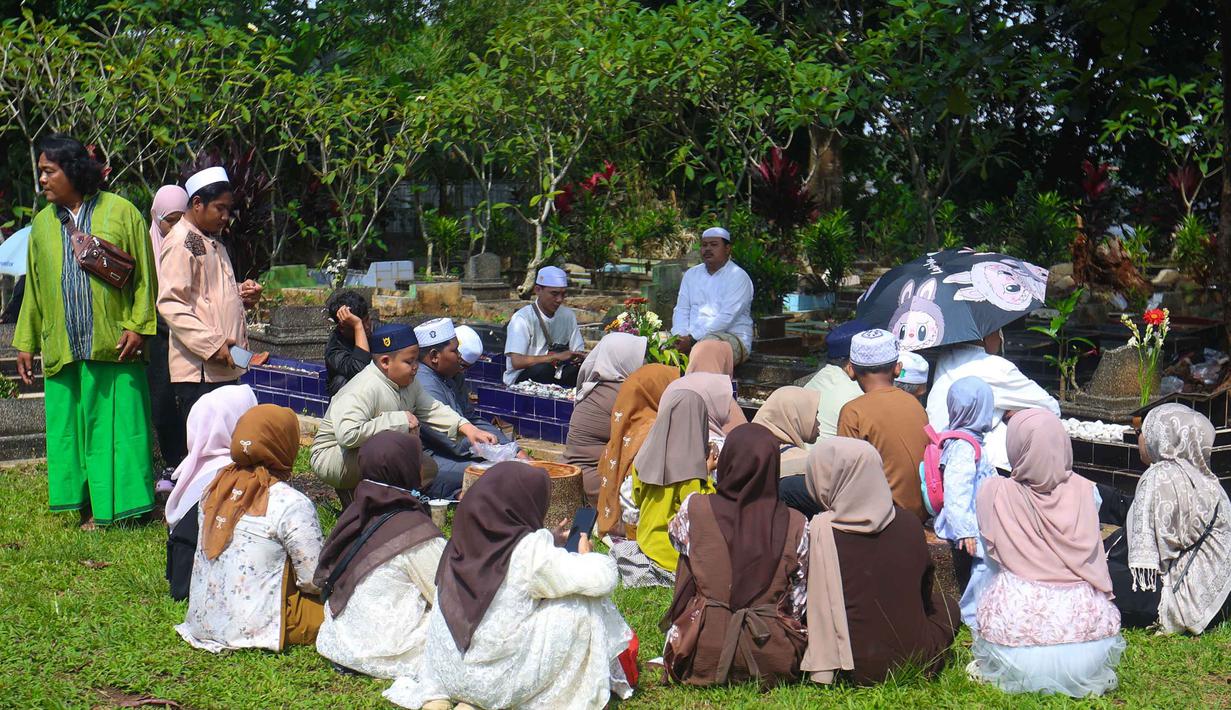 Tradisi ziarah kubur terus dijaga oleh sebagian masyarakat, sebagai bagian dari nilai budaya dan spiritual yang melekat dalam perayaan Idul Fitri. Tampak dalam foto, warga saat melakukan ziarah kubur usai melaksanakan salat Idulfitri 1447 Hijriah di salah satu Tempat Pemakaman Umum (TPU), Cibinong, Kabupaten Bogor, Jawa Barat, Sabtu (21/3/2026). (Kapanlagi.com/Budy Santoso)