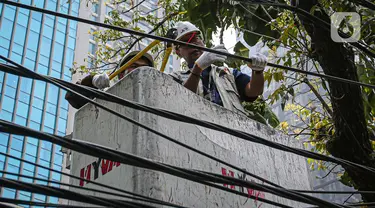 Petugas dari Dinas Bina Marga didampingi JIP memotong kabel fiber optik yang semrawut di kawasan Jalan Senopati, Jakarta, Kamis (24/8/2023). (Liputan6.com/Faizal Fanani)