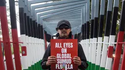 Seorang aktivis berpose saat aksi solidaritas menentang pencegatan kapal-kapal yang berpartisipasi dalam armada Global Sumud Flotilla, sebuah misi bantuan kemanusiaan warga sipil ke Gaza melalui laut, di Bandung, Jawa Barat, pada Selasa 19 Mei 2026. (Timur Matahari/AFP)
