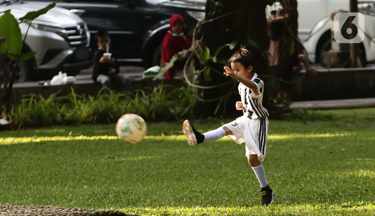 Anak-anak bermain bola di ruang terbuka hijau Taman Suropati, Jakarta, Sabtu (23/10/2021). Selama berada di ruang terbuka hijau, pengunjung diwajibkan mematuhi protokol kesehatan, seperti mencuci tangan, mengenakan masker dan menghindari kerumunan. (Liputan6.com/Helmi Fithriansyah)