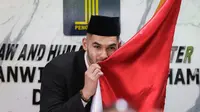 Sandy Walsh mencium bendera Merah Putih di depan wartawan usai pengambilan sumpah janji setia pewarganegaraan Jordi Amat dan Sandy Walsh di Kantor Wilayah Kemenkumham DKI Jakarta, Cawang, Jakarta, Kamis (17/11/2022). (Bola.com/Bagaskara Lazuardi)