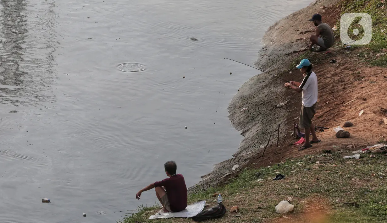 Warga melakukan aktivitas mancing di Kanal Banjir Barat, Jakarta, Selasa (9/6/2020). Fase pertama PSBB transisi di Ibukota dimanfaatkan warga untuk memancing. (Liputan6.com/Johan Tallo)