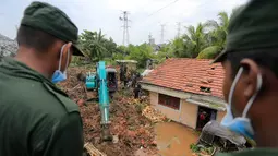 Tentara Sri Lanka berupaya menyelamatkan para korban yang terperangkap gunungan sampah di Meetotamulla, dekat ibukota Kolombo, Minggu (16/4). Ratusan tentara mencari korban yang tertimbun penampungan sampah dengan alat berat. (AP Photo/Eranga Jayawardena)