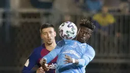 Bek Barcelona, Clement Lenglet (kiri) berebut bola dengan gelandang UD Ibiza, Kwasi Sibo pada pertandingan babak 32 besar Copa del Rey 2019-2020 di Estadi Municipal de Can Misses, Rabu (21/1/2020). Barcelona harus bersusah payah untuk mengalahkan Klub Segunda B UD Ibiza 2-1. (JAIME REINA/AFP)