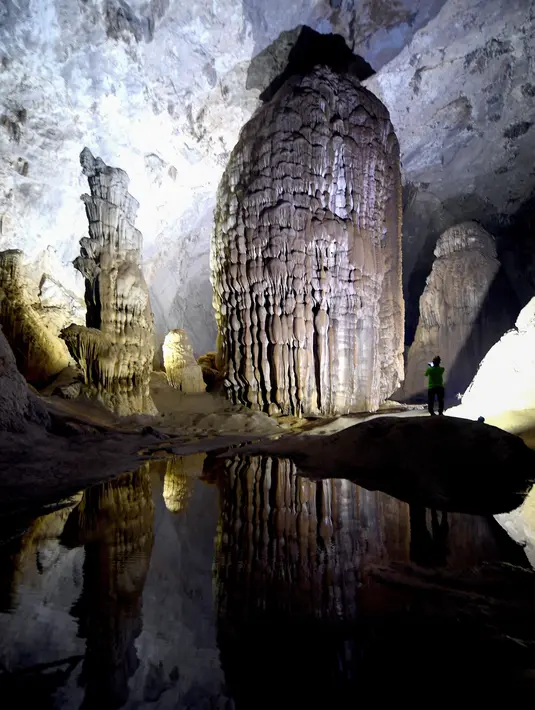 Foto pada 18 Januari 2021 menunjukkan seorang pengunjung di gua Son Doong, salah satu gua alam terbesar di dunia, selama tur di provinsi Quang Binh, Vietnam. Son Dong dalam bahasa Vietnam artinya sungai gunung, karena di dalamnya terdapat aliran sungai deras yang mengalir. (Nhac NGUYEN/AFP)