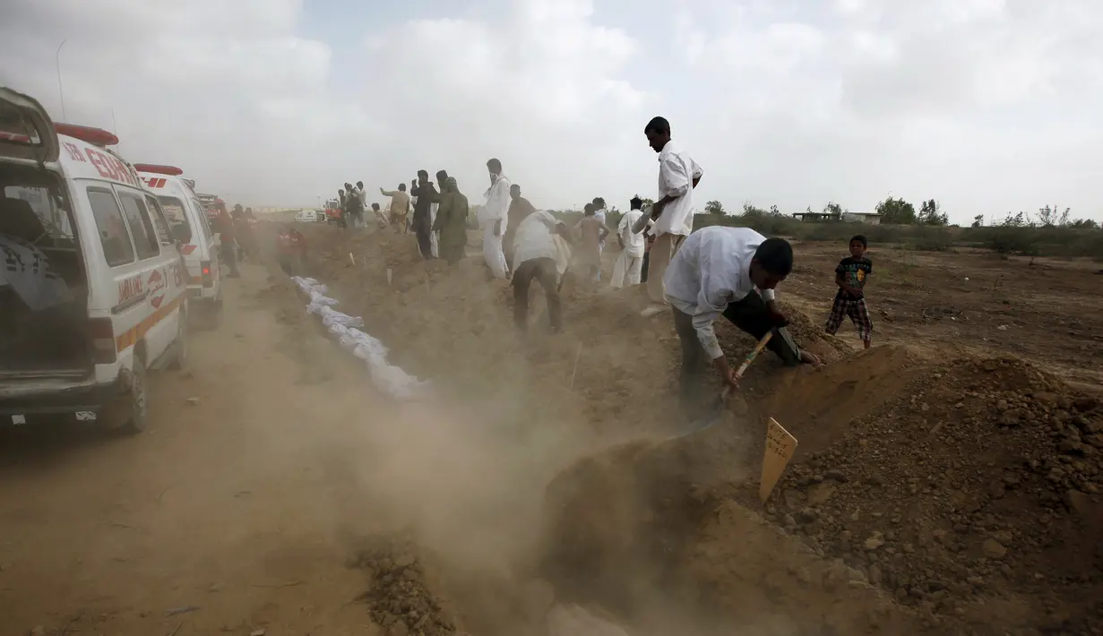 Sejumlah relawan menguburkan jenazah korban tewas akibat gelombang panas saat pemakaman massal di Karachi, Pakistan, Jumat (26/6/2015). Lebih dari 1.150 orang tewas akibat gelombang panas. (REUTERS/Akhtar Soomro)