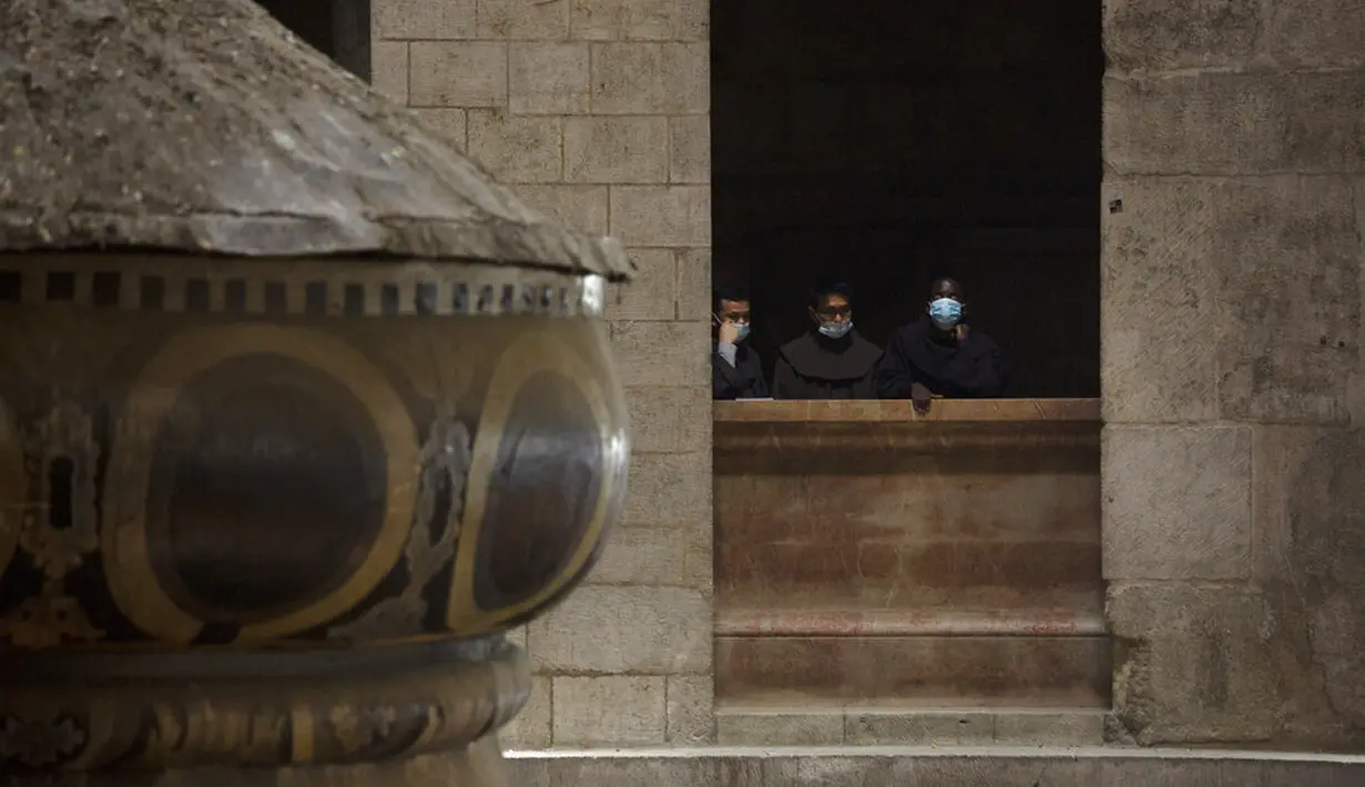 Para imam Fransiskan menyaksikan dari balkon dekat puncak Makam Kudus selama misa Kamis Putih yang dipimpin oleh Patriark Latin Yerusalem di Kota Tua Yerusalem, Kamis (1/4/2021). Kamis Putih adalah hari Kamis sebelum Paskah. (AP Photo/Maya Alleruzzo)