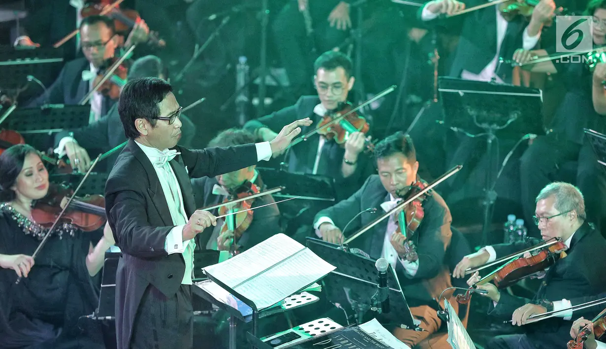 Konduktor Musik Addie MS memimpin pertunjukan konser outdoor bertema Symphony Under The Stars di Lippo Mall Kemang, Jakarta, Sabtu (28/7). Mereka membawakan sountrack film terfavorit baik dari dalam maupun luar negeri. (Liputan6.com/Fery Pradolo)