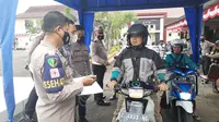 Petugas kesehatan polres Tasikmalaya, Jawa Barat tengah melakukan pendataan kepada pengendara roda dua yang akan melakukan vaksinasi booster. (Liputan6.com/Jayadi Supriadin)