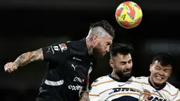 Pemain Monterrey, Sergio Ramos (kiri) berduel udara dengan pemain Puma, Ruben Duarte dalam laga lanjutan Liga Meksiko atau Liga MX Clausura di Olimpico Universitario Stadium, Meksiko pada Minggu (16/03/2025). (AFP/Yuri Cortez)