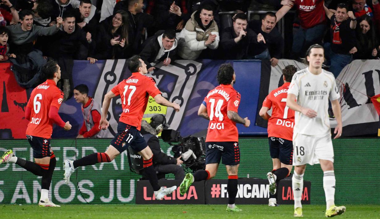 Hasilnya, Los Rojillos unggul lebih awal lewat eksekusi titik putih Ante Budimir pada menit ke-38. Tampak dalam foto, penyerang Osasuna asal Kroasia, Ante Budimir (kedua kiri) merayakan golnya selama pertandingan pekan ke-25 La Liga 2025/2026 melawan Real Madrid di Stadion El Sadar, Pamplona pada Sabtu 21 Februari 2026 waktu setempat atau Minggu (22/2/2026) dini hari WIB. (ANDER GILLENEA/AFP)