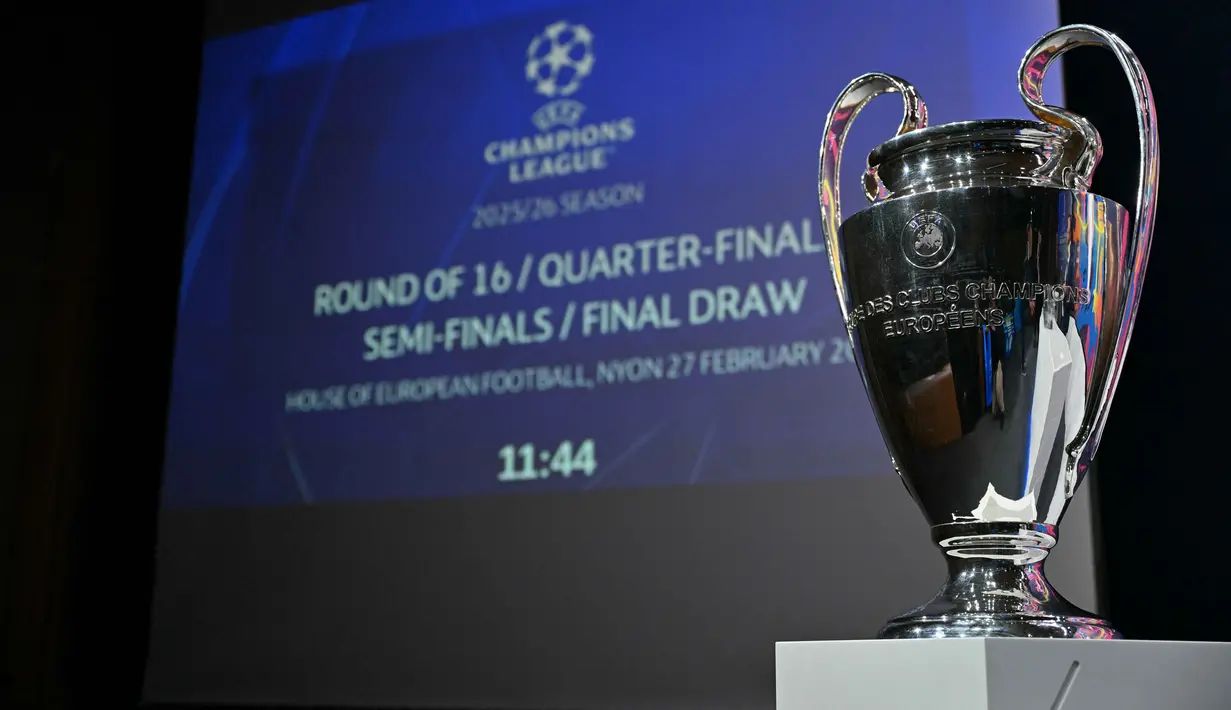 Dipandu Direktur Kompetisi UEFA Giorgio Marchetti dan mantan gelandang Barcelona, Ivan Rakitic, undian menghadirkan banyak partai besar. Tampak foto yang menunjukkan Piala Liga Champions UEFA menjelang pengundian babak 16 besar, perempat final, dan semifinal Liga Champions 2025/2026 di House of European Football di Nyon, Swiss, Jumat (27/2/2026). (Harold CUNNINGHAM/AFP)