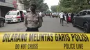 Seorang petugas polisi berjaga di jalan menuju  insiden ledakan yang terjadi Polsek Astana Anyar, Bandung, Jawa Barat, Rabu (7/12/2022). Polri menyatakan ledakan yang terjadi pagi ini sekitar pukul 08.15 WIB di Polsek Astana Anyar Kota Bandung diduga merupakan aksi bom bunuh diri. (AP Photo/Ahmad Fauzan)