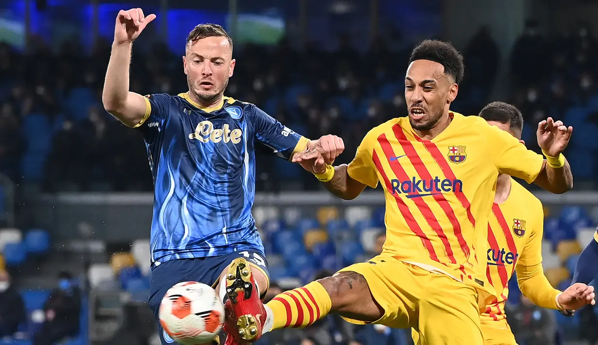 Bek Napoli Amir Rrahmani  berebut bola dengan gelandang Barcelona Pierre-Emerick Aubameyang pada play-off fase gugur Liga Europa 2021/2022 di Stadion Diego Armando Maradona, Jumat (25/2/2022) dini hari WIB. Barcelona melaju ke babak 16 besar usai menang 4-2 di kandang Napoli. (ANDREAS SOLARO/AFP)