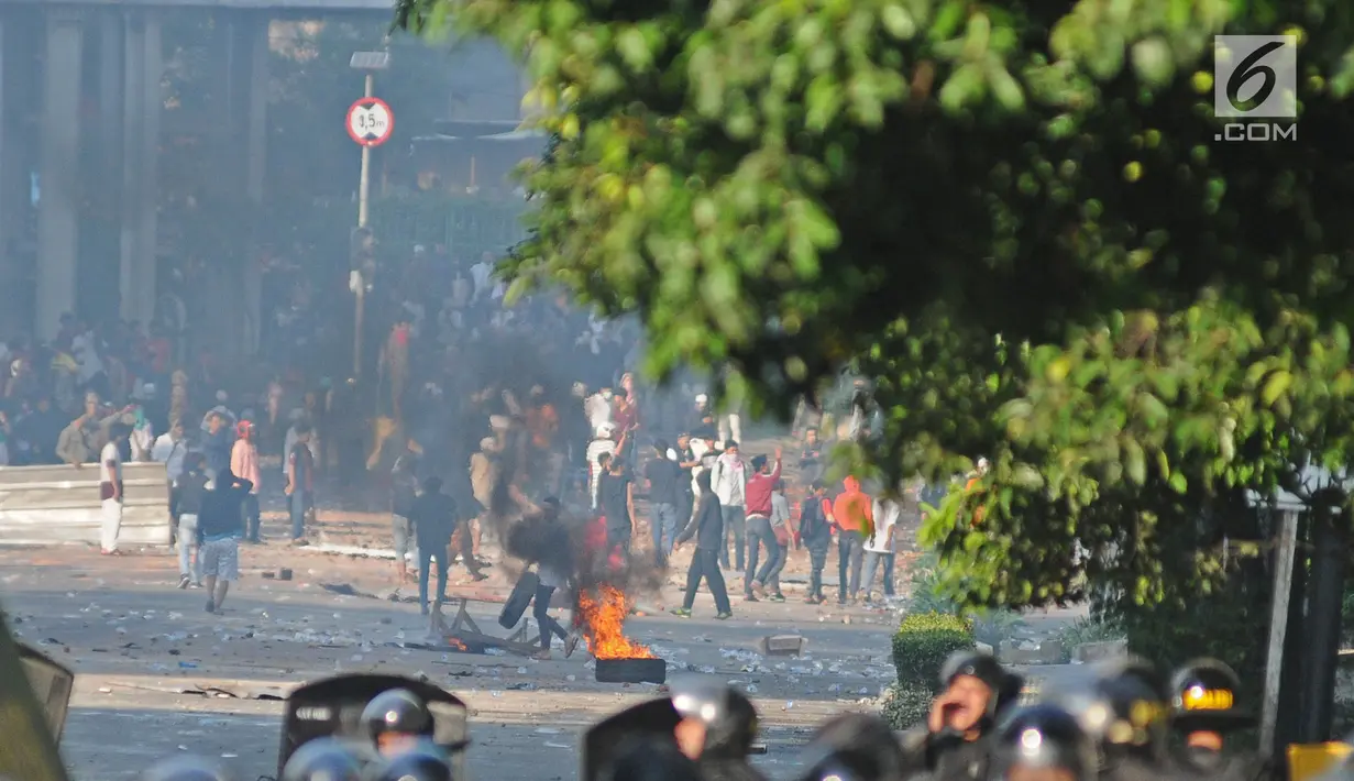 Bentrok antara polisi dan massa aksi di kawasan Tanah Abang, Jakarta, Rabu (22/5/2019).  Beberapa kelompok massa menggunakan benda-benda keras hingga mercon untuk menahan laju petugas keamanan. (Liputan6.com/Herman Zakharia)