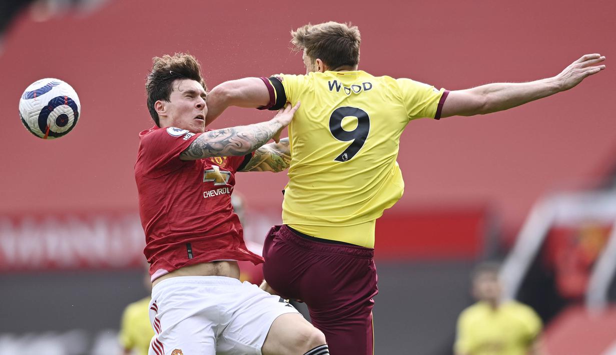 Bek Manchester United, Victor Lindelof, duel udara dengan pemain Burnley, Chris Wood, pada laga Liga Inggris di Stadion Old Trafford, Minggu (18/4/2021). MU menang 3-1 Burnley. (Stu Forster/Pool via AP)