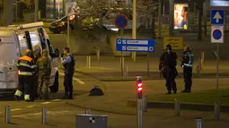 Pasukan bersenjata melakukan evakuasi di Bandara Schiphol, Amsterdam, Belanda, Selasa (12/4), sesaat setelah alarm peringatan keamanan berbunyi. Selain mengevakuasi warga, aparat juga  menangkap satu orang dalam kejadian itu. (Michel van Bergen/ANP/AFP)