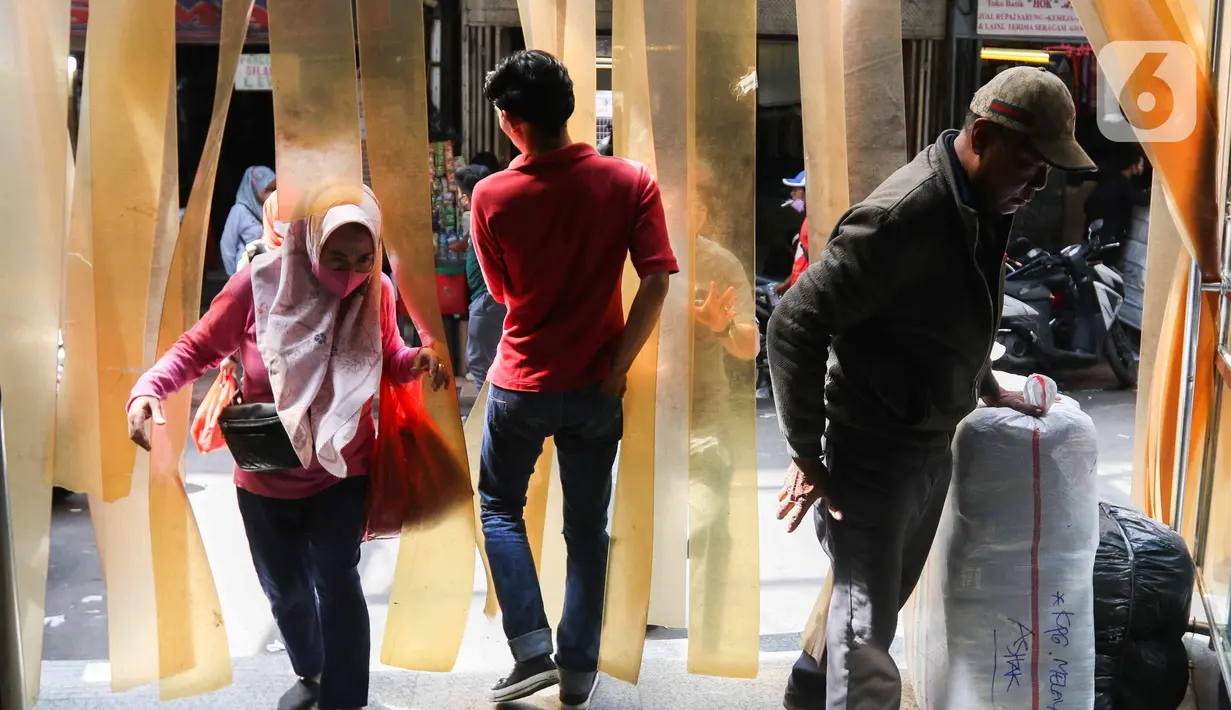 Pembeli membawa barang belanjaan di Pasar Tanah Abang, Jakarta, (28/3/2022). Sepekan menjalang bulan suci Ramadan, Pasar Tanah Abang mulai dipadati pembeli yang hendak berbelanja untuk kebutuhan bulan puasa. (Liputan6.com/Herman Zakharia)
