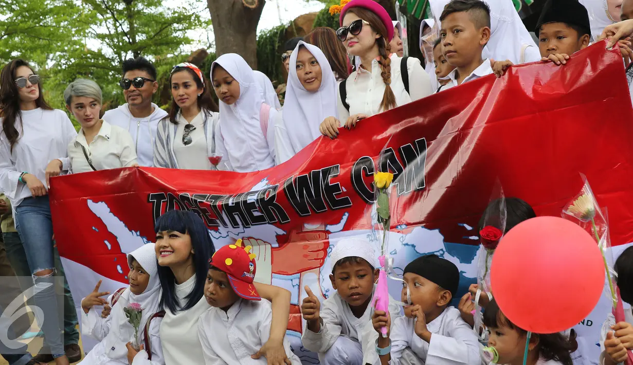 Julia Perez (bawah) berpose dengan sejumlah anak saat merayakan ulang tahun yang 36 di kawasan Ancol, Jakarta, Jumat (15/7). Sejumlah selebriti hadir dalam acara tersebut diantaranya Luna Maya dan Zaskia Gotik. (Liputan6.com/Herman Zakharia)