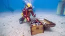 Penyelam mengambil botol anggur yang disimpan dalam peti di dasar Laut Mediterania di Saint-Mandrier, Prancis selatan, 15 Mei 2017. Sejumlah penyelam Prancis melakukan percobaan proses pematangan anggur di dalam air selama setahun. (Boris HORVAT/AFP)