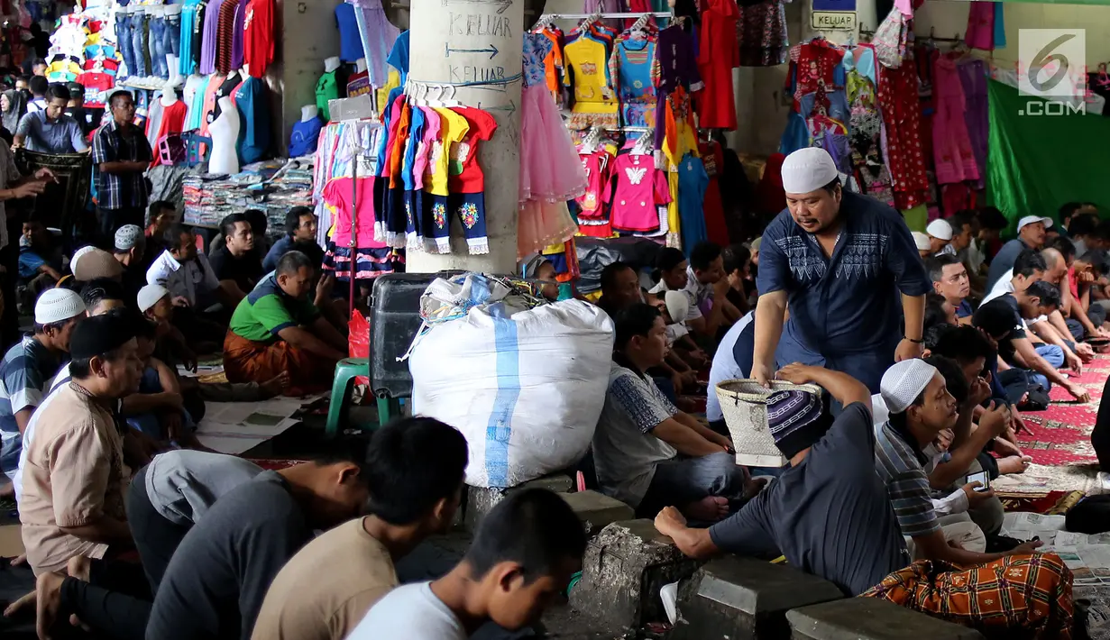 Umat muslim mendengarkan ceramah sebelum melaksanakan salat Jumat di pasar Tanah Abang, Jakarta, Jumat (9/6). Dikarenakan membeludaknya jamaah yang ingin beribadah mereka terpaksa melakukan sholat di antara kios-kios pasar. (Liputan6.com/Johan Tallo)