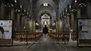Seorang jemaah berdoa saat stiker jaga jarak sosial terpasang di kursi setelah kebaktian Kamis Putih di Gereja Saint Pierre de Montrouge, Paris, Prancis, Kamis (1/4/2021). Prancis bersiap melakukan lockdown setelah pemerintah menemukan adanya lonjakan kasus COVID-19. (AP Photo/Francois Mori)