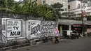 Pejalan kaki melintas di depan mural di kawasan Jakarta Pusat. Selasa (24/8/2021). Mural 'Tuhan Aku Lapar' yang viral di jagat maya pada akhir Juli 2021 lalu, membuka rentetan peristiwa penghapusan mural di kota-kota besar Indonesia. (Liputan6.com/Johan Tallo)