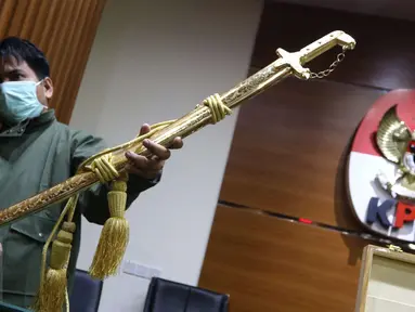 Petugas menunjukkan pedang emas pemberian Raja Arab Saudi Salman bin Abdulaziz Al Saud di Gedung KPK, Jakarta, Kamis (16/3). Total nilai barang-barang yang diterima dari rombongan Raja Salman itu ditaksir mencapai Rp 5 miliar. (Liputan6.com/Helmi Afandi)