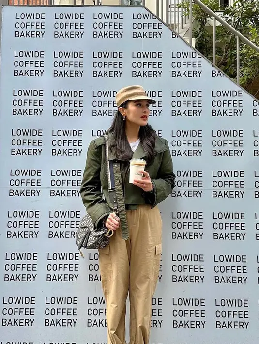 Ibu dua anak ini juga memilih mengenakan jaket crop top hijau army yang dipadukan celana warna beige serasi dengan topinya dan boots hitam. [@sandradewi88]