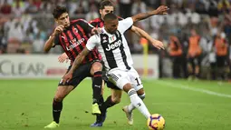 Pemain Juventus, Douglas Costa (kanan) berebut bola dengan pemain AC Milan, Lucas Paqueta (kiri) pada laga final di King Abdullah Sports City, Kamis (17/1). Juventus keluar sebagai kampiun dengan meraih kemenangan tipis 1-0. (Fayez Nureldine / AFP)