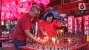 Warga keturunan Tionghoa menyalakan lilin saat sembahyang Vihara Amurva Bhumi, kawasan Karet Semanggi, Jakarta, Jumat (24/1/2020) malam. Ibadah tersebut dalam rangka menyambut Tahun Baru Imlek 2571/2020. (Liputan6.com/Herman Zakharia)