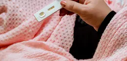 Ilustrasi perempuan yang menunjukkan tes kehamilan/copyright unsplash.com/Amr Taha
