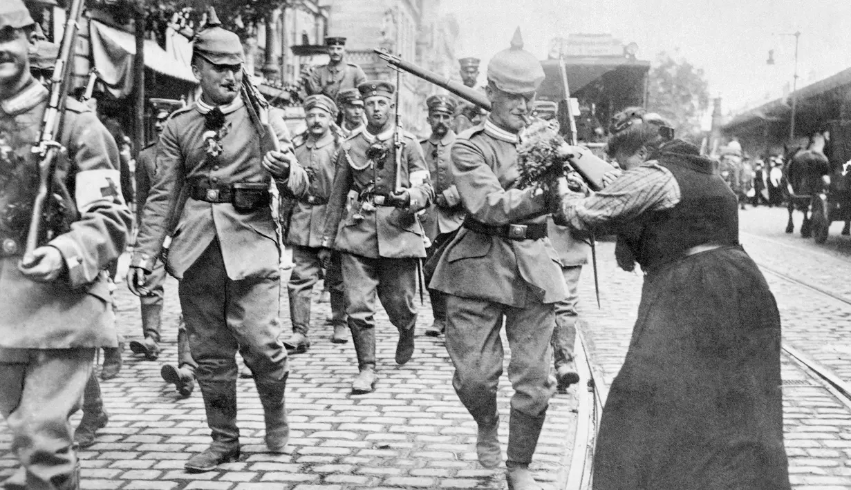 Prajurit Prusia yang meninggalkan Berlin diberi bunga oleh seorang wanita selama Perang Dunia I. Perang Dunia I membuka jalan untuk berbagai perubahan politik seperti revolusi di beberapa negara yang terlibat. (AP Photo, File)